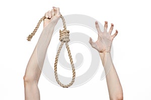 Lynching and suicide theme: man's hand holding a loop of rope for hanging on white isolated background