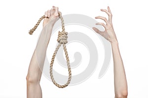 Lynching and suicide theme: man's hand holding a loop of rope for hanging on white isolated background