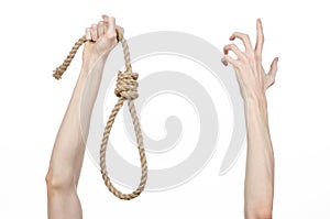 Lynching and suicide theme: man's hand holding a loop of rope for hanging on white isolated background