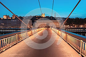 Lyon night cityscape with illuminated Courthouse and red pedestrian bridge over Saone river. Panoramic