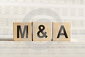 M&A abbreviation - mergers and acquisitions, on wooden cubes on a light background