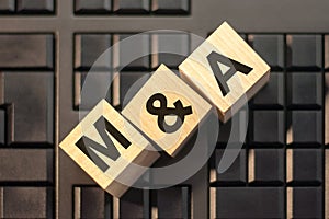 M A - acronym from wooden blocks with letters, concept. M and A - Mergers and Acquisitions photo