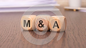 M and A - Mergers and Acquisitions word concept on cubes photo