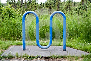M-shaped blue bike rack among nature