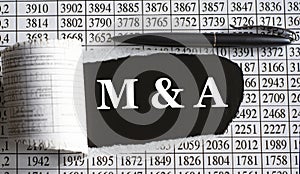 M&A is the word behind torn office paper with numbers and a black pen