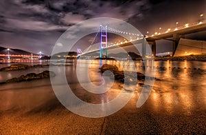 Ma Wan Island Suspension Bridge from the Beach at Night with Vibrant Reflections in the Water, Hong Kong