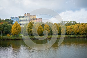 The Maas-Waal Canal with apartment buildings and trees in autumn