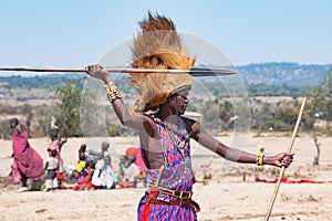 Maasai man, warrior, typical garb and male lion mane on head, spear in hand, Tanzania