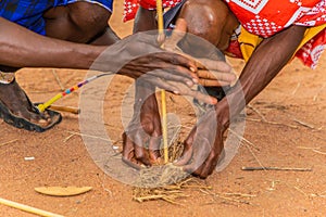 Maasai men make fire in the traditional way