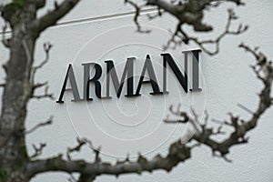 Armani trademark sign, through a tree at Maasmechelen village outlet
