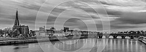 Black and white panoramic image of the skyline of Maastricht  with views on the Sint Servaas bridge, the boat company for day trip