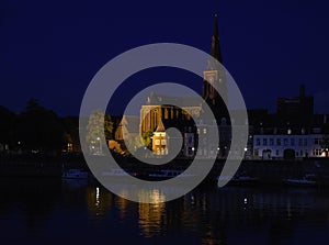 Maastricht at night, the Dutch city on the river Maas with boats