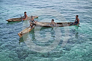 MABUL ISLAND, SABAH. local sea kids playing around at crystal clear water at Mabul Island