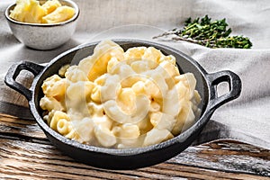 Mac and cheese, american style macaroni pasta in cheesy sauce. White wooden background. Top view photo