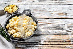 Mac and cheese, american style macaroni pasta in cheesy sauce. White wooden background. Top view. Copy space