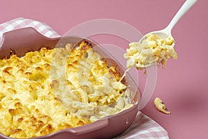 Mac and cheese baked in bechamel sauce. Macaroni with cheese on a spoon