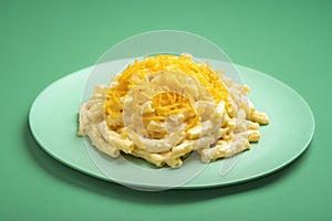 Mac and cheese on a plate isolated on a green background