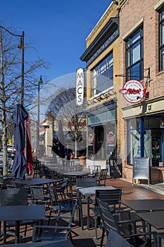 Macâs Chophouse with a red brick sidewalk lined with shops, restaurants and bars with tables and chairs on the sidewalk