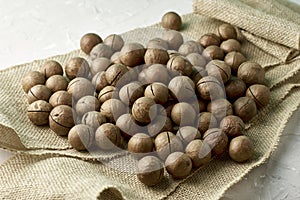 A macadamia nuts on burlap background backdrop