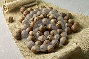 A macadamia nuts on burlap background backdrop