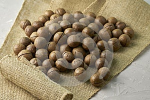 A macadamia nuts on burlap background backdrop