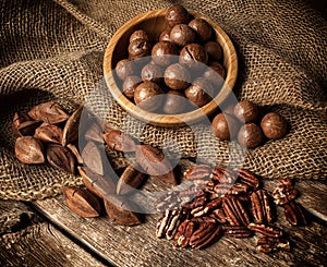 Macadamia, Pecan and Pili nuts on wooden table