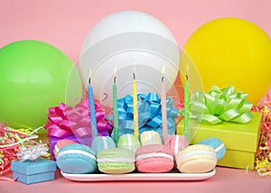 Macaron birthday party with candles balloons and colorful presents