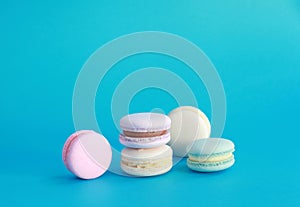 Macaron or macaroon on turquoise background, colorful almond cookies with different fillings