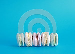 Macaron or macaroon on turquoise background, colorful almond cookies with different fillings