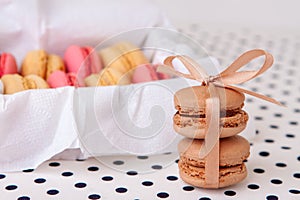 Macaroni cakes with vanilla and chocolate filling close-up tied with a ribbon.