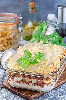 Macaroni casserole with ground beef, cheese and tomato in glass  baking dish, vertical