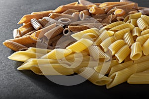 Macaroni from durum wheat on a black background.