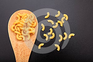 Macaroni in a ladle, black background