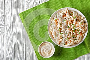 Macaroni salad in a white bowl, top view