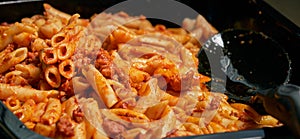 Macaroni and tomato sauce ready to serve. Image of prepared catering food at the time of serving the dishes