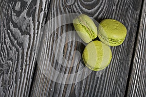 Macarons cakes light green color. They lie on black and white pine boards