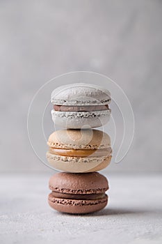 Macarons chocolate, caramel and vanilla on light background