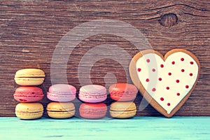 Macarons and heart-shaped cookie on a blue rustic surface