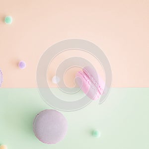 Macarons and pompoms on pastel background