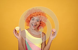 macaroon cookie. happy childhood. birthday party. funny kid in clown wig hold french macaron.