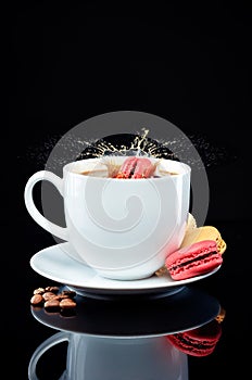 A macaroon splashes a cup of coffee on glass surface