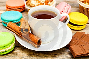 Macaroon with tea, chocolate and cinnamon sticks