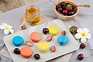 Macaroons and berries on wooden background