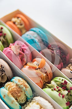 Macaroons in box. French macaroon cake. Sweet macarons or macaroons, flavored cookies are in the paper box on white