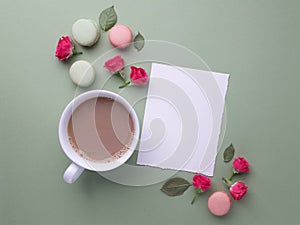 Macaroons, coffee and rose on green background. Top view. Flat lay