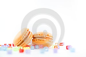 Macaroons with colorful cube letters on white background top, color macaroons, selective focus