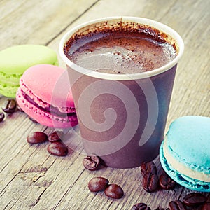 Macaroons and espresso coffee cup on old wooden rustic table