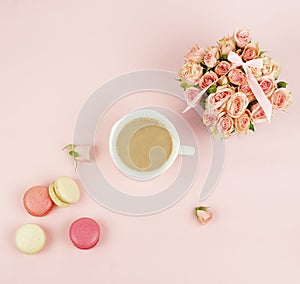 Macaroons in pastel colors with bouquet pink roses flowers