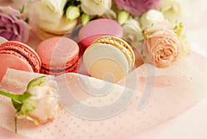 Macaroons in pastel colors with flowers on a pale pink background.Holiday background