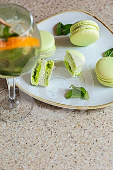 Macaroons on a plate on a gray background. French macarons isolated. Selective focus. Beautiful green macaroons with